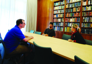 Aaron Shukuda, assistant director of ITALIC, a new residential arts immersion program housed in Stern Hall's Burbank dorm, meets with students in a newly-renovated learning space. (Madeline Sides/The Stanford Daily)