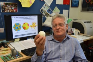 Professor James Swartz holds an enlarged replica of a virus-like particle. Swartz and his team have re-engineered a virus to deliver therapies to cells. (Stanford News Service, Linda Rice)