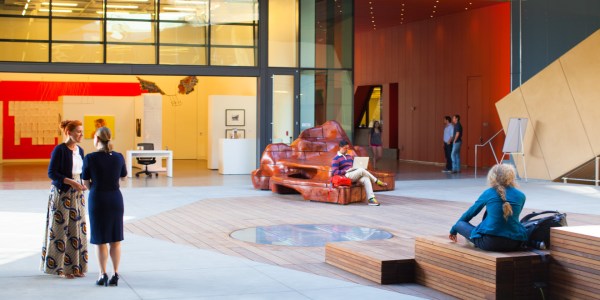 People talk about things at the McMurtry building, which is artsy and large. The people seem to enjoy talking. "How was your salad?" "Fine, thank you." "I do not think the tomato is a fruit." "Yes."