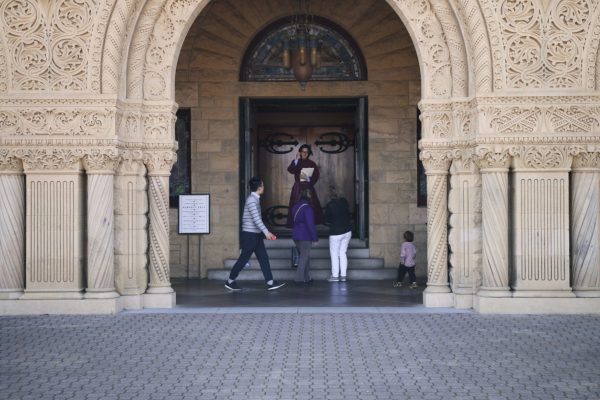 A student passes by the doors to Memorial Church in Main Quad.