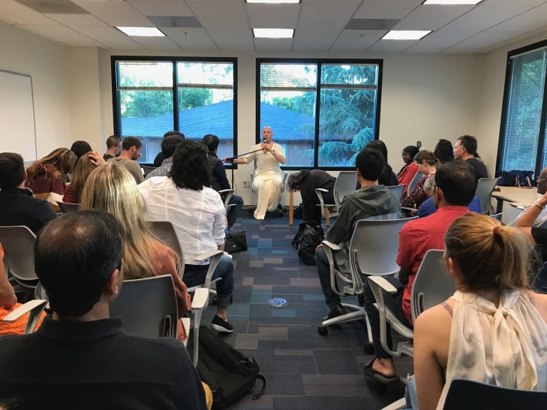 Monk and Bhakti yoga practitioner Vaisesika Dasa leads a crowd through guided meditation during an event on finding spiritual balance. (MANAT KAUR/The Stanford Daily)