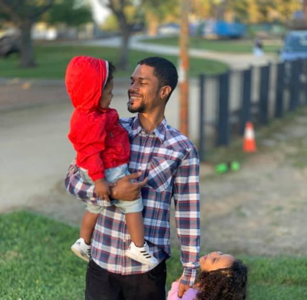 Princeton Lacy Moore stands with two of his children. He was 35 at the time of his death on Nov. 21. (Photo courtesy of Monik Gordon)