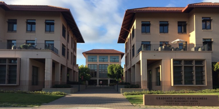 Two buildings in the front, with one building peeking in between the two buildings in the back.