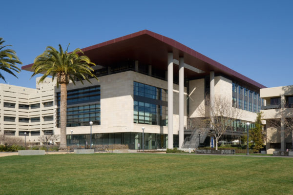 Entrance to the Li Ka Shing building, next to a grass lawn and palm trees, at the Stanford School of Medicine