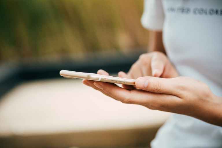 Close up of young person navigating their iPhone with their finger