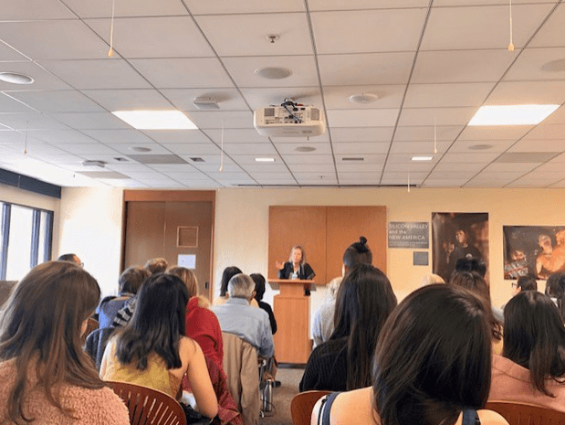 Louise Gluck speaks in front of a crowd at a 2020 event.