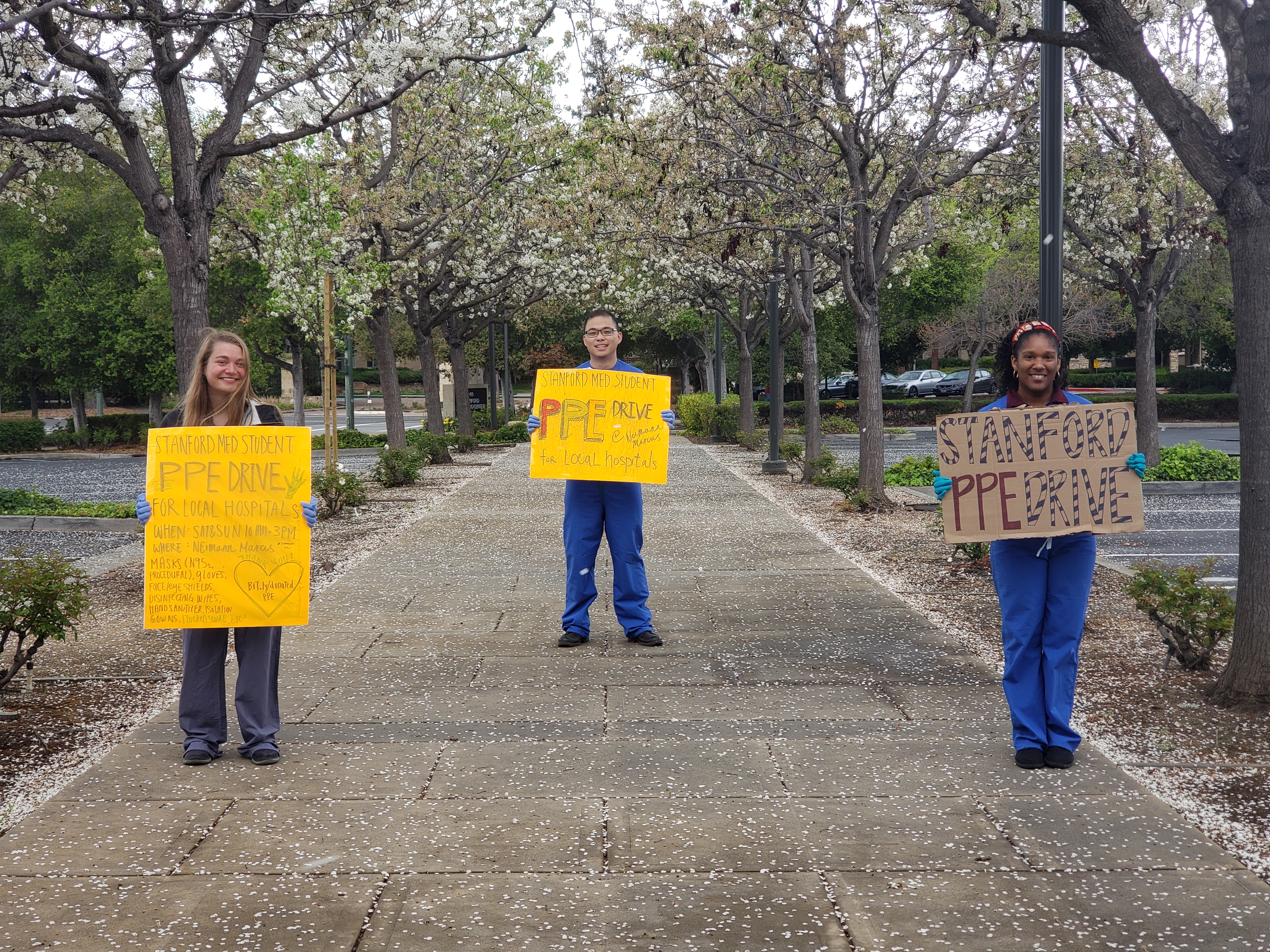 The volunteers pose with colorful signs, standing a safe, CDC-approved six feet apart.