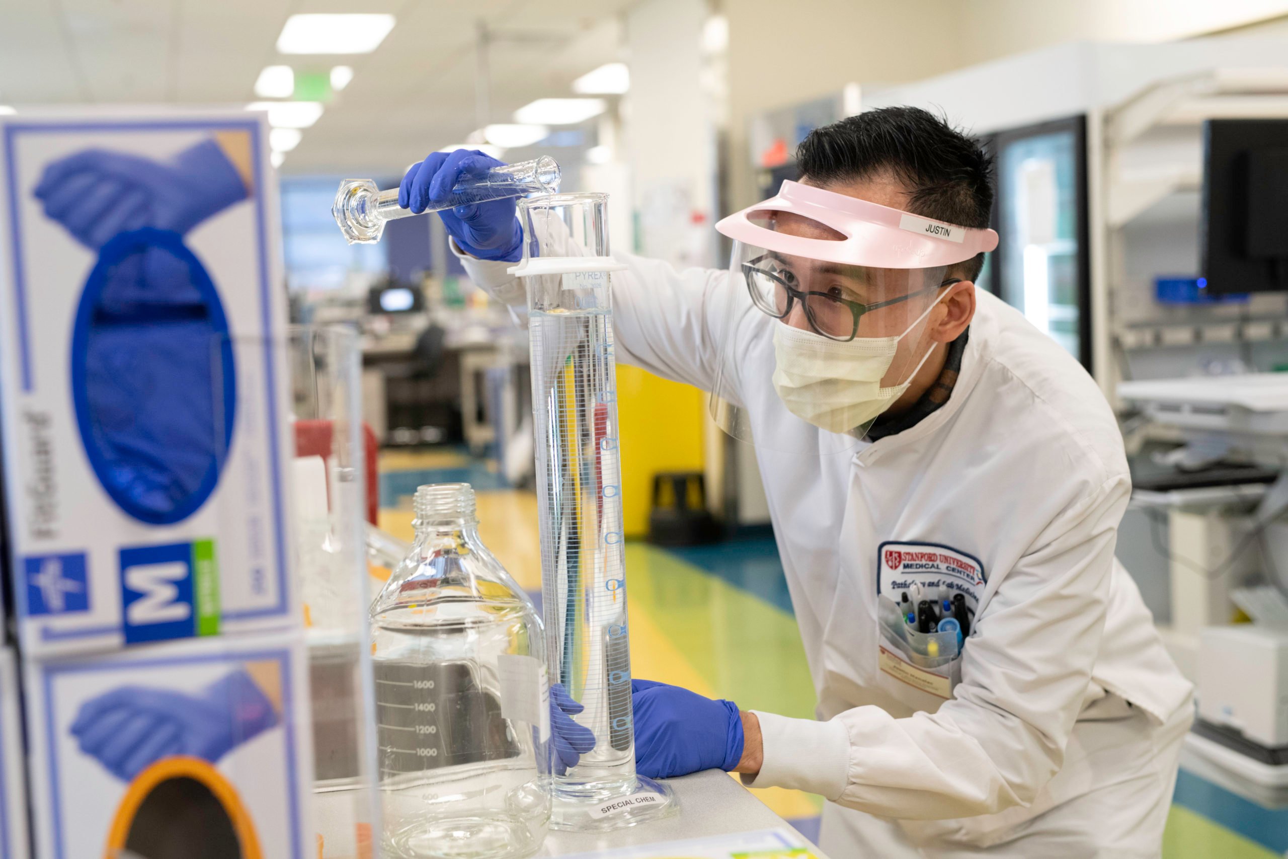 A researcher pours something into a container.