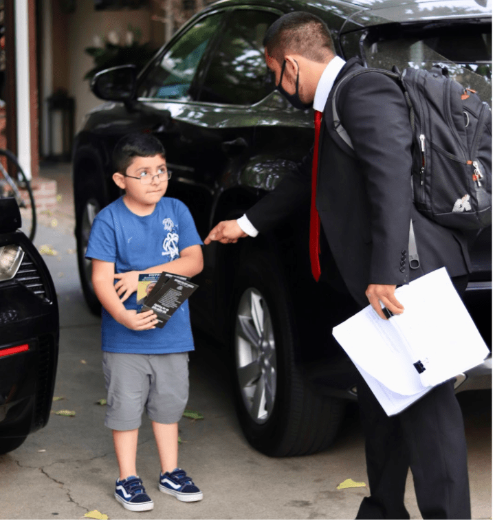 Antonio López handing campaign materials to a resident of East Palo Alto. (Photo courtesy of  Antonio López)