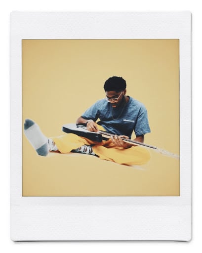 Seyi Olujide sitting down with a guitar