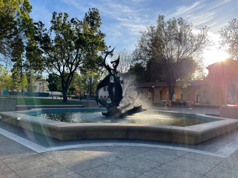 The Claw fountain with beams of light refracting through the trees