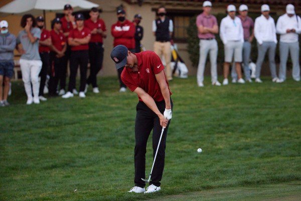 Sophomore Michael Thorbjornsen hits a chip from behind the 18th green.