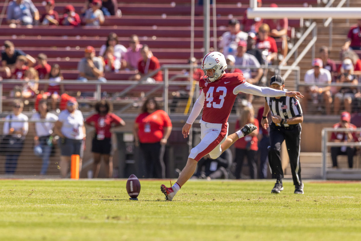 Sophomore kicker Joshua Karty extends his leg back to kick a football on the field.