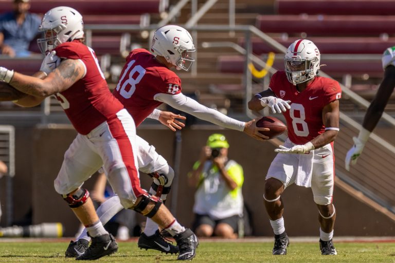 Tanner McKee hands the ball off to Nathaniel Peat during a play.