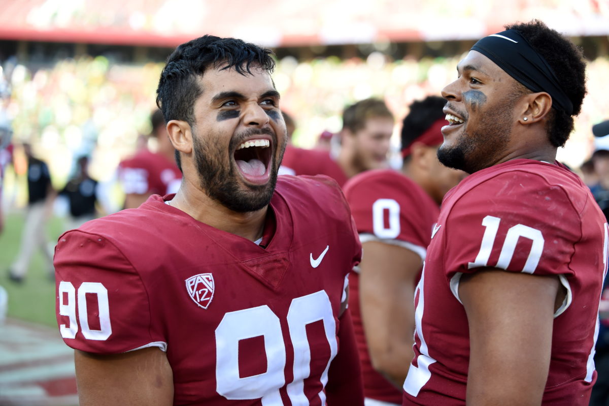 Two football players Gabe Reid and Jordan Fox smile with their helmets off. 