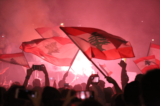 Crowd of protestors waving Lebanese flag