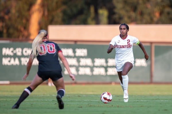 Naomi Girma dribbles the ball towards a defender.