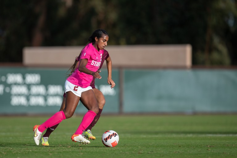 Naomi Girma dribbles the ball.