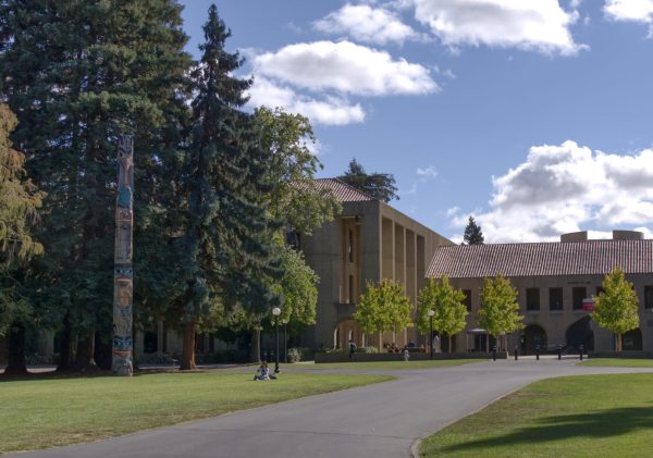 A totem pole next to a pathway leading to a building