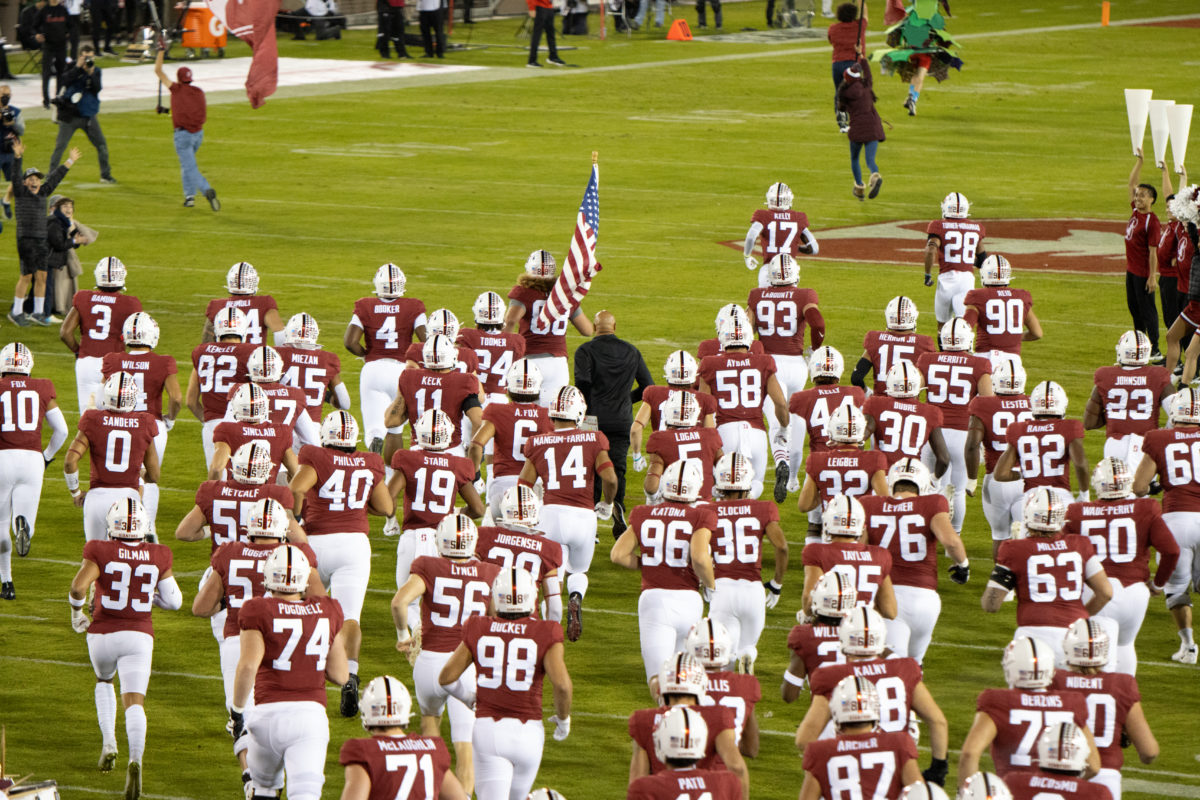 Stanford football running onto the field