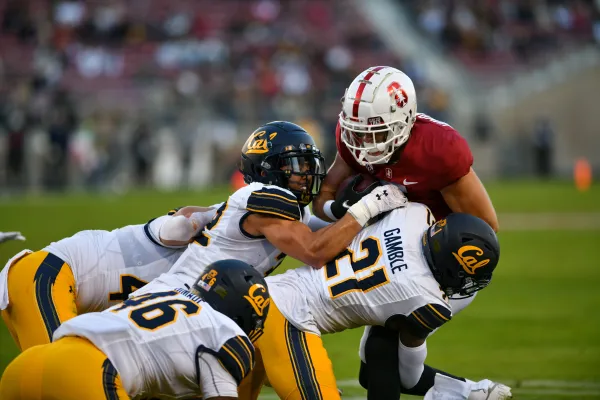 A photo of sophomore wide receiver John Humphreys being tackled by Cal defenders