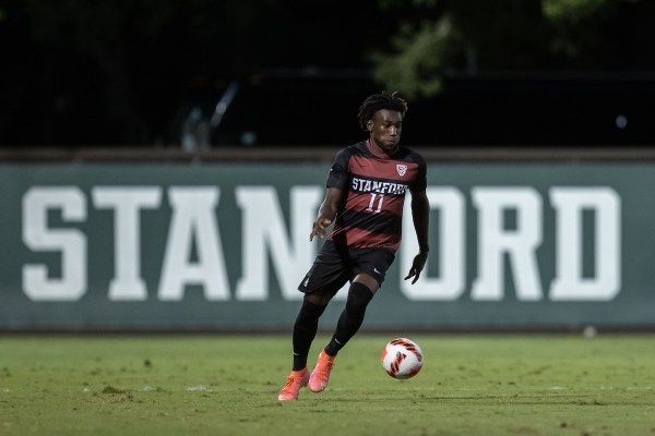 A player dribbles the soccer ball up the pitch.