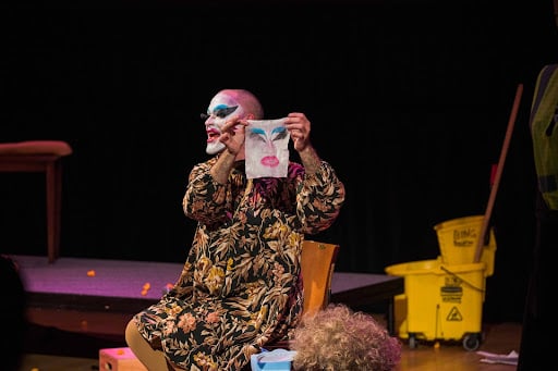 Drag clown Carla Rossi holds up a makeup wipe with her makeup residue during drag performance