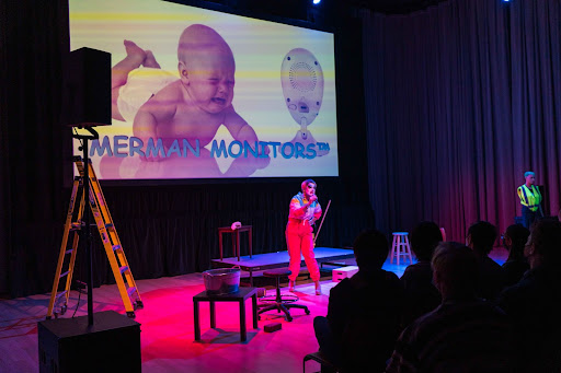 A photo of Rossi on stage with a projector screen depicting a baby