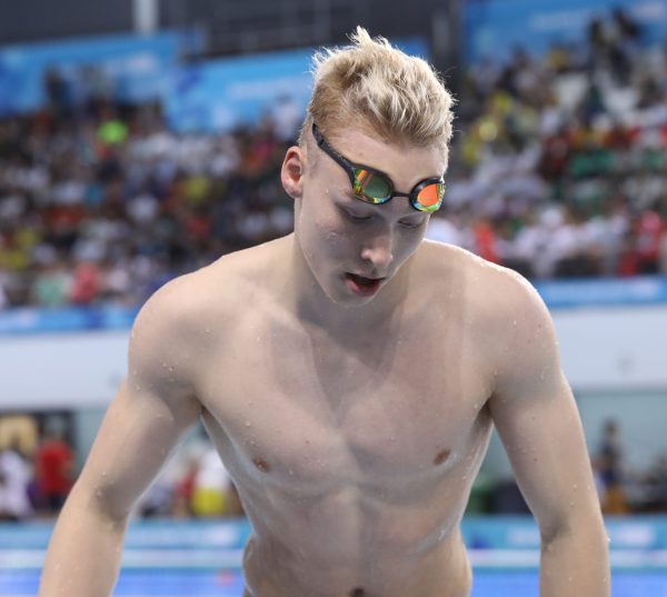 Andrei Minakov in front of pool and audience