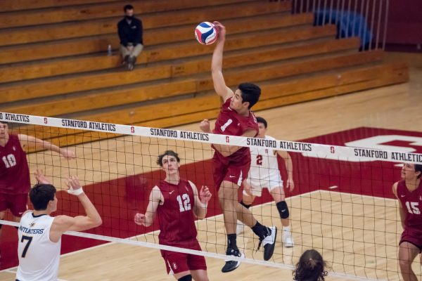 Adam Chang jumps above the net to hit the ball.