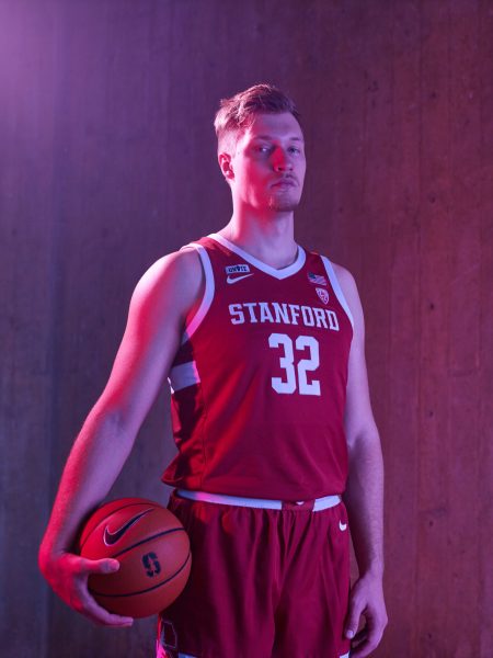 A man stands for a photo with a basketball.