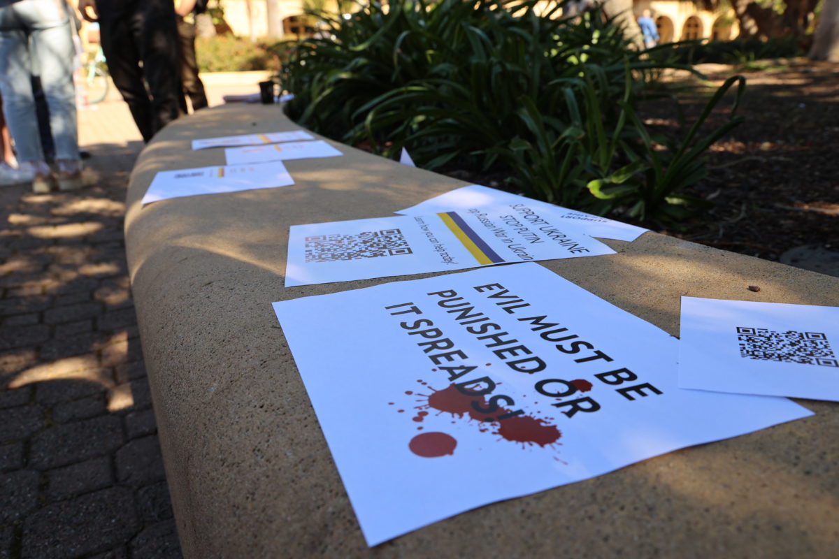 Flyers reading "Evil Must Be Punished Or It Spreads" on bench