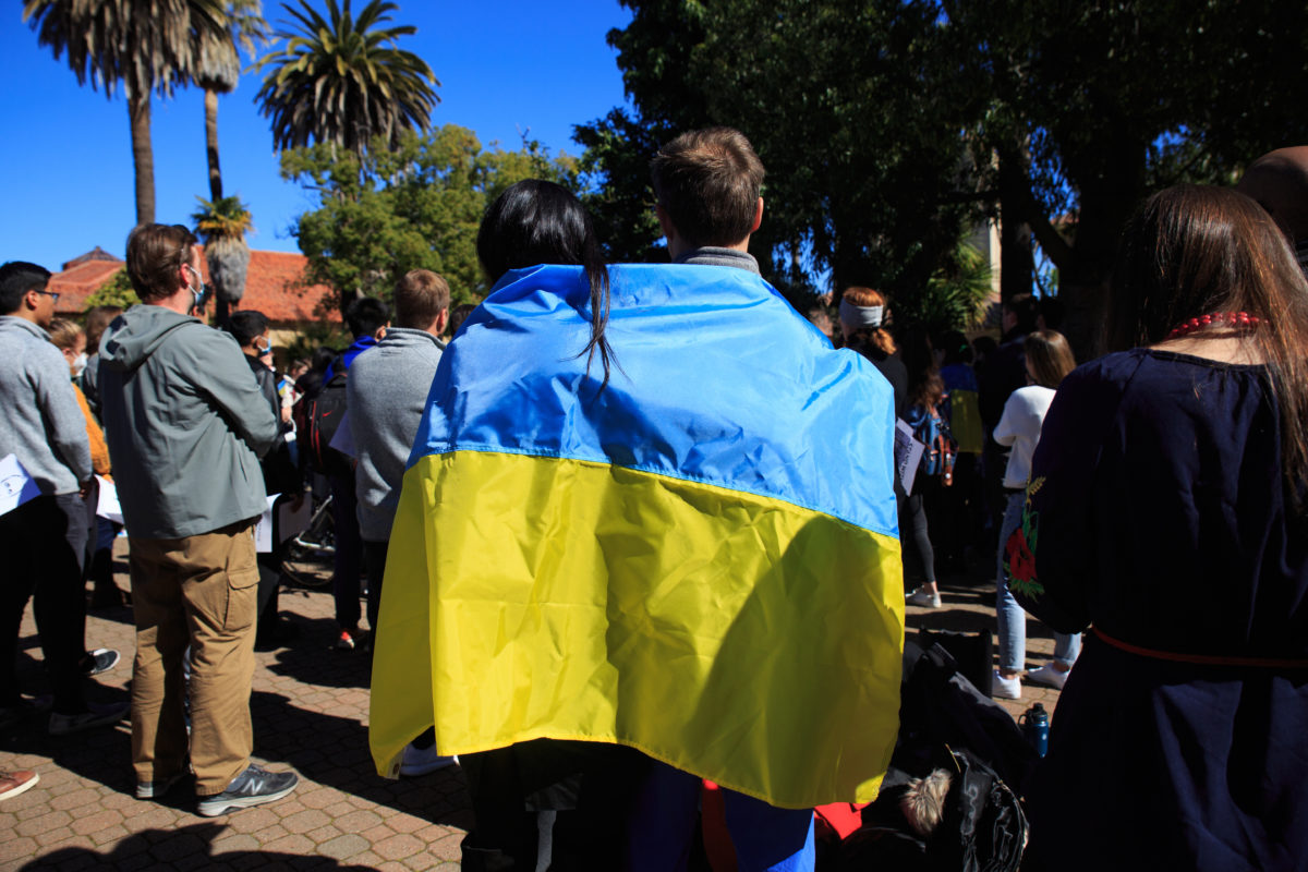 Two students from behind with draped in Ukrainian flag