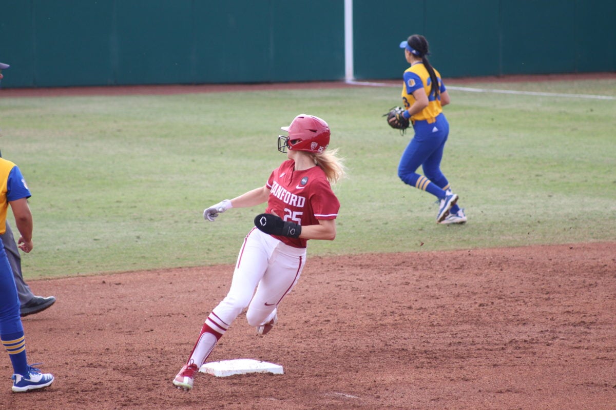 Taylor Gindlesperger runs past a base while looking at the player in the outfield.