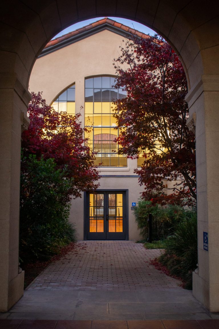 Front of Stanford building framed by Autumnal trees