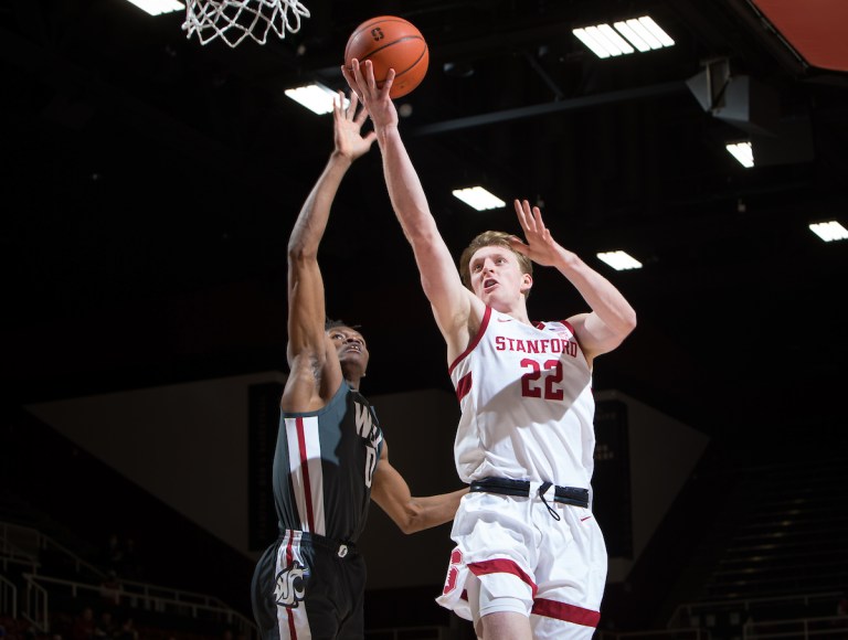 James Keefe reaches the ball to the basket as a Washington player attempts to defend.