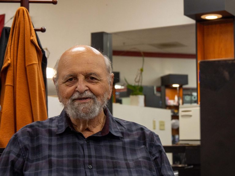 Cogliandro poses for a headshot photo in a plaid shirt