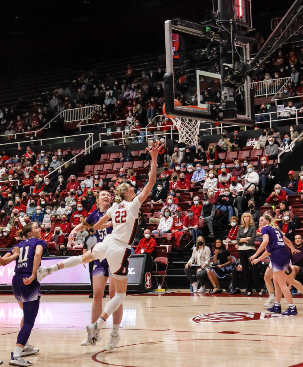 Cam Brink drives the ball to the basket with two Washington defenders around her.