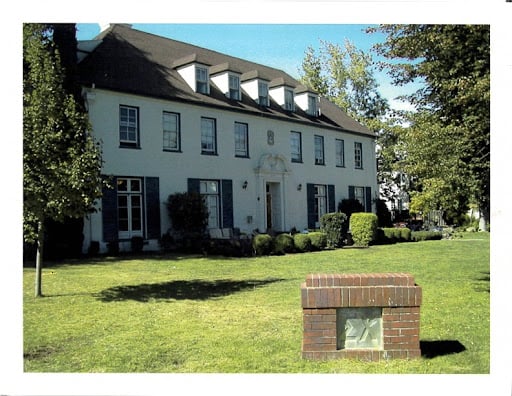 A large white house with a green front lawn that used to house the Sigma Chi fraternity