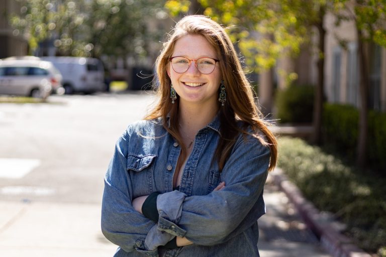 Kate Frimet stands smiling for a portrait photo.