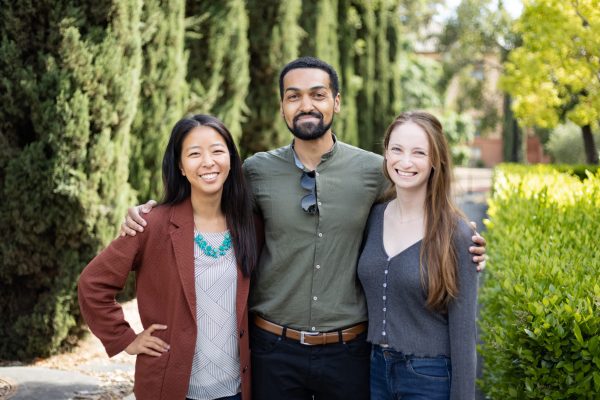 Stella Liu, Joseff Kolman and Georgia Kossoff posing for a photo in front of trees.