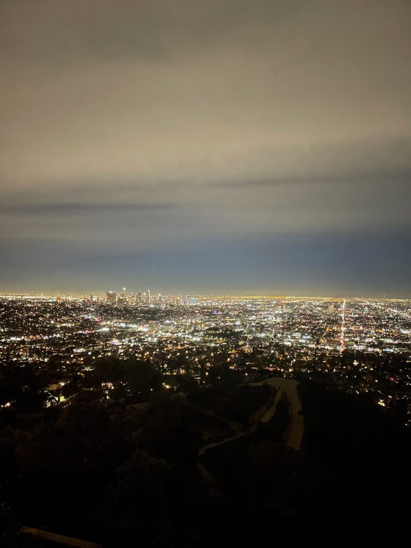 From the view of a high location at night, a city of lights along its streets.