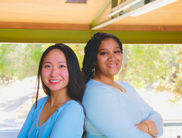 Emily Nichols and Michaela Phan stand back to back smiling