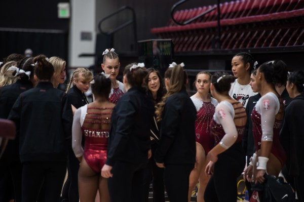 Stanford women's gymnastics gather as a team.