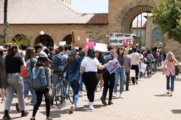 Students march through main quad with signs protesting Dobbs v. Jackson