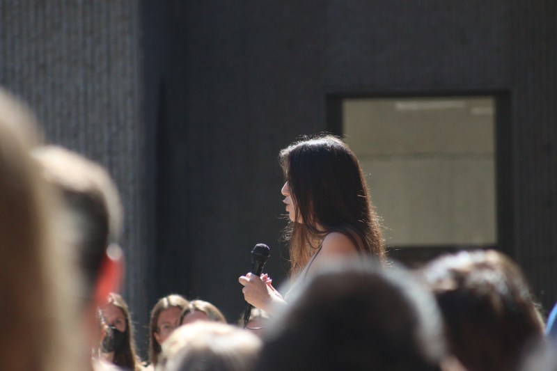 A student organizer speaks to the crowd at Cooley Courtyard.