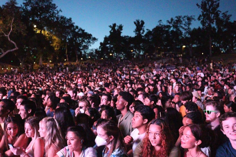 crowd shot of students facing frost stage, faces cast in pink glow