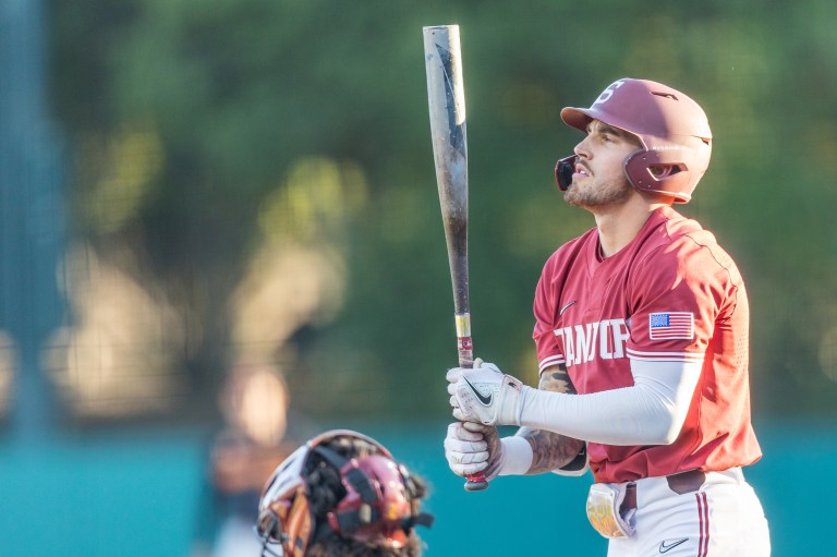 Brock Jones looks at his bat before walking up to the plate to hit.