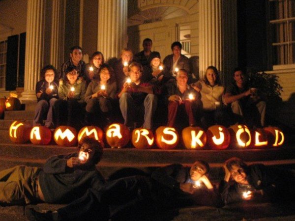 Residents of Hamm holding candles sit behind jack-o-lanterns that spell out "Hammerskjöld"