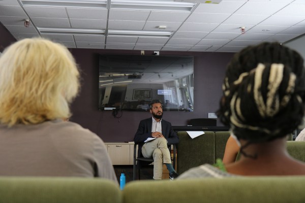 SLE alum Elias Rodriques '13 sits in front of a group of students in the FloMo lounge.